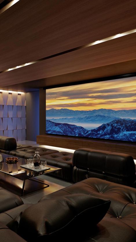 An elegant home theater with a panoramic screen displaying a mountain landscape at sunrise, plush leather seating, and a sleek, modern design.